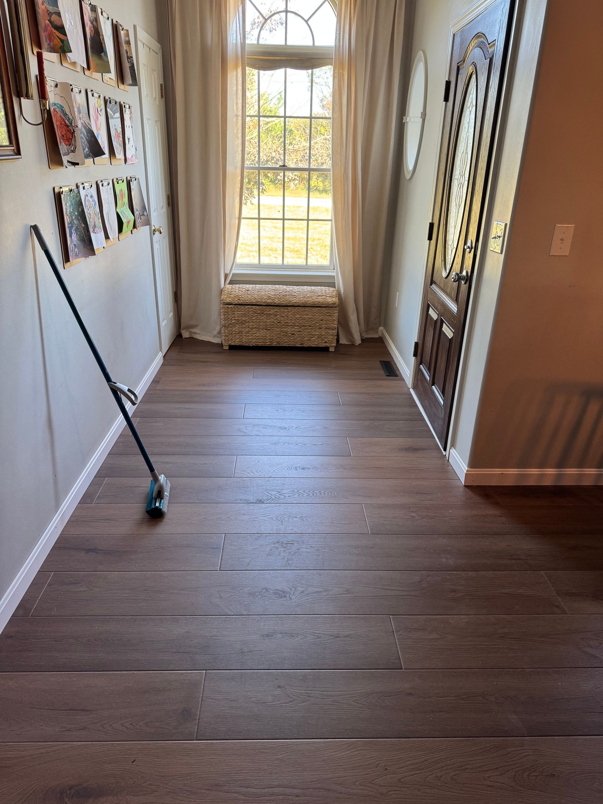 Long hallway with hardwood floors, window seat at the end, and a golf club leaning against the wall.