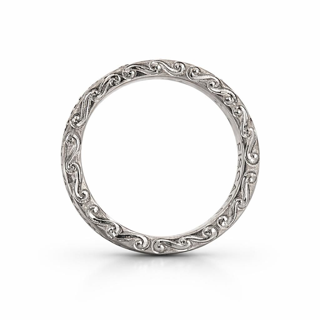 A silver wedding band with intricate, continuous floral-style filigree engraving against a plain white background.