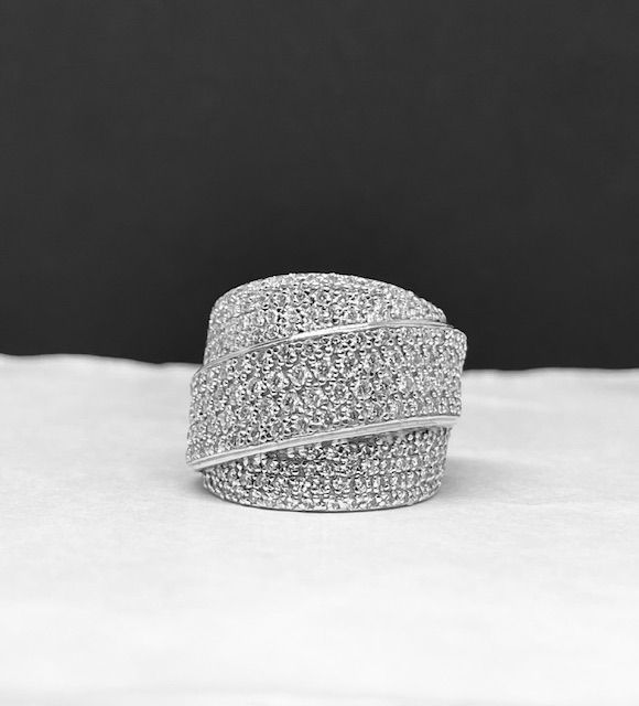 Silver ring encrusted with small, round, light-colored stones in a wrapped design.