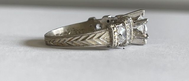 Silver engagement ring with a large center stone and detailed band.