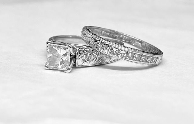 Two ornate silver rings with clear square and small square gemstones.