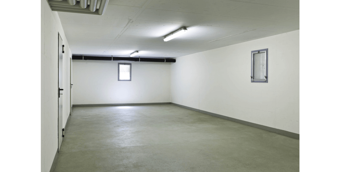 basement with two lights, a window and concrete flooring