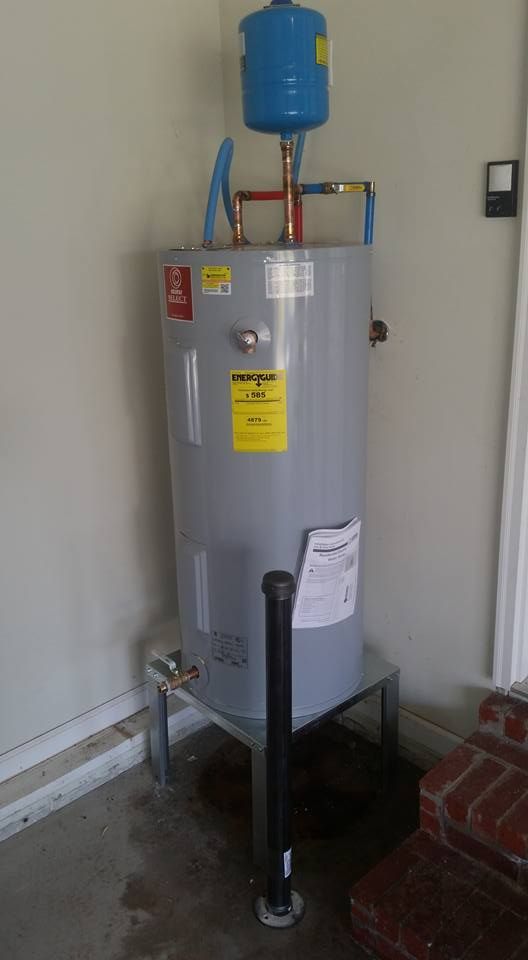A water heater is sitting on top of a metal stand in a garage.