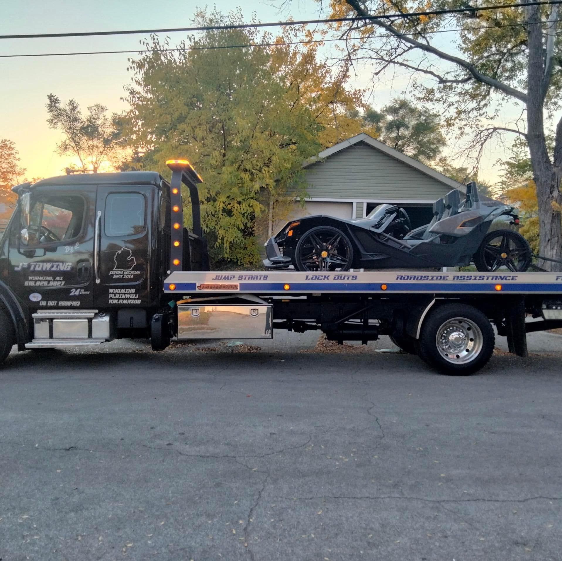 A tow truck with a motorcycle on the back of it