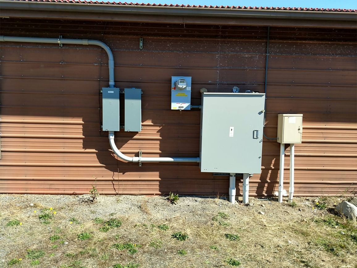 An electrical box is attached to the side of a building