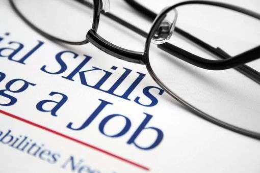 Close-up of glasses over a resume highlighting skills and job qualifications