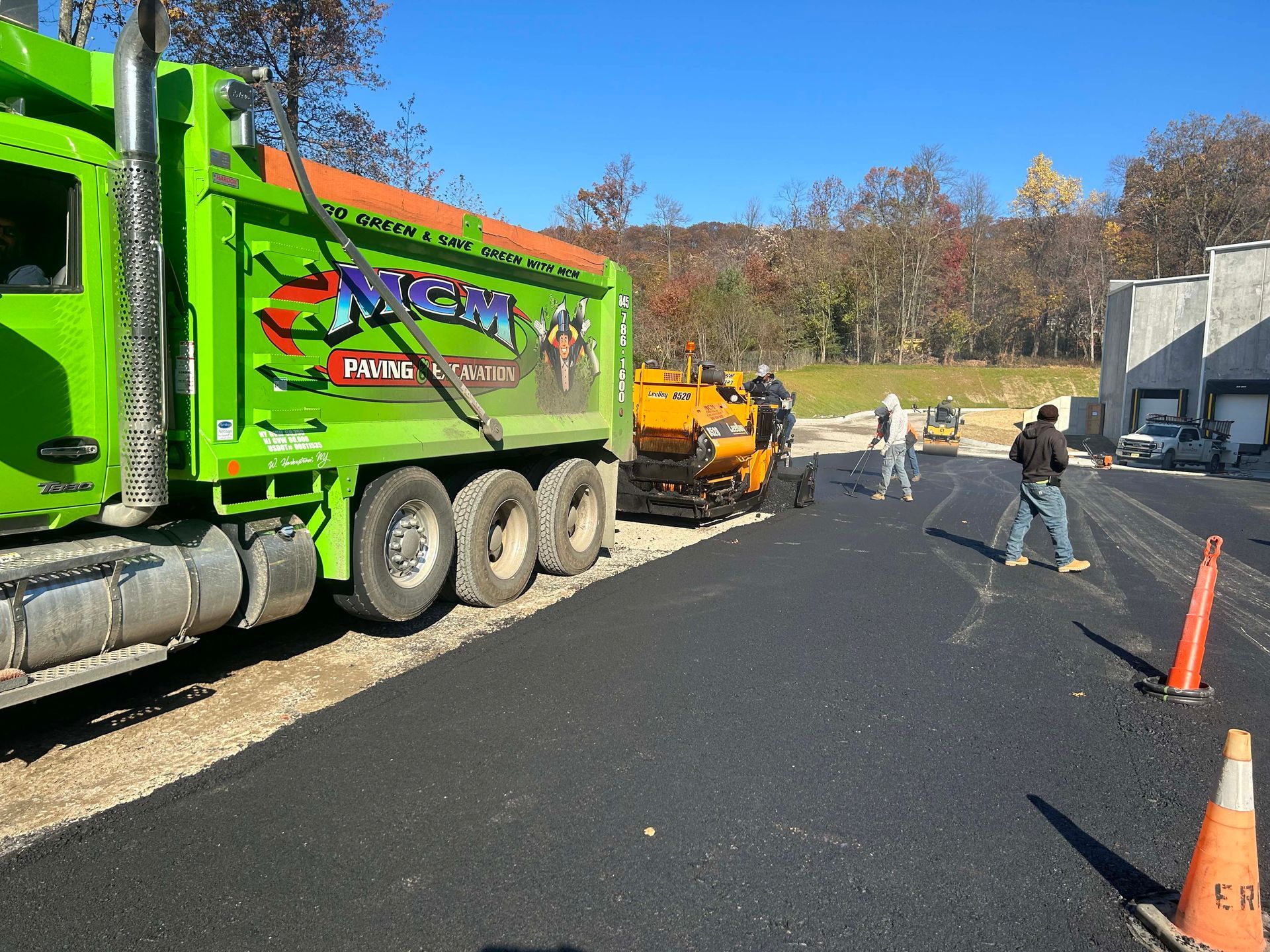 A green dump truck with the word asphalt on it