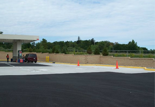 A red van is parked in front of a gas station