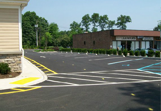 A parking lot with a corner store in the background