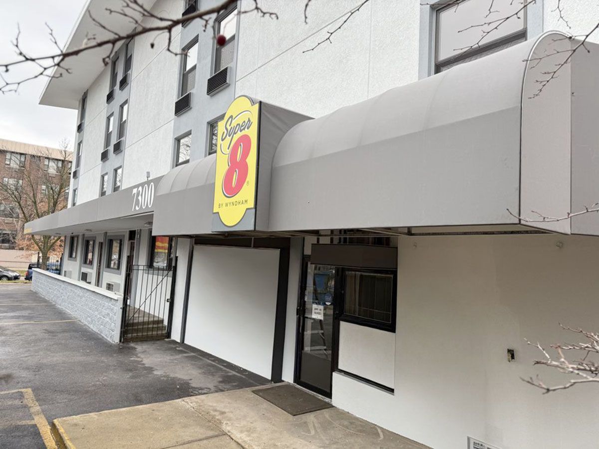 Exterior view of a motel with a gray awning and signage