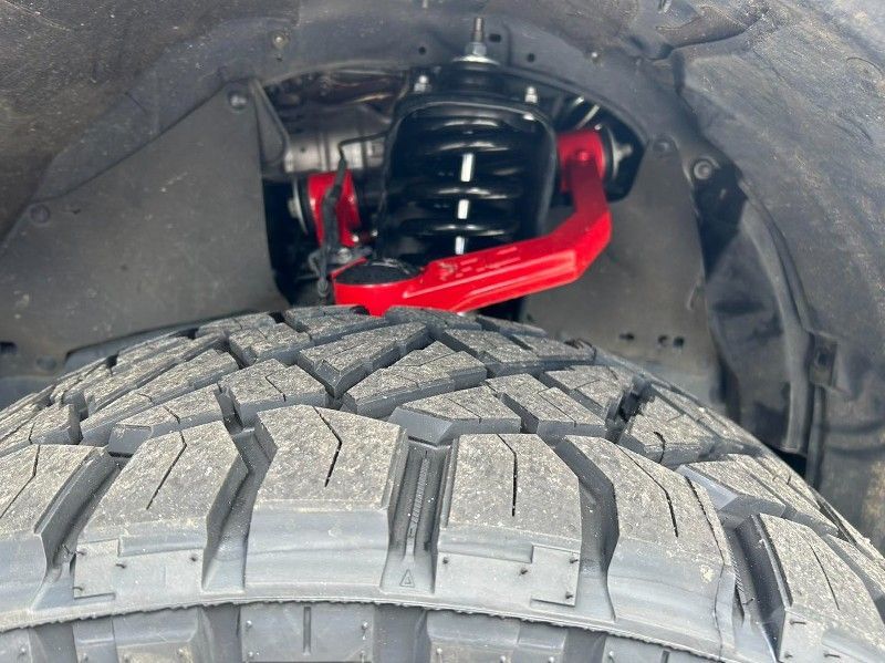 A close up of a tire and shock on a truck