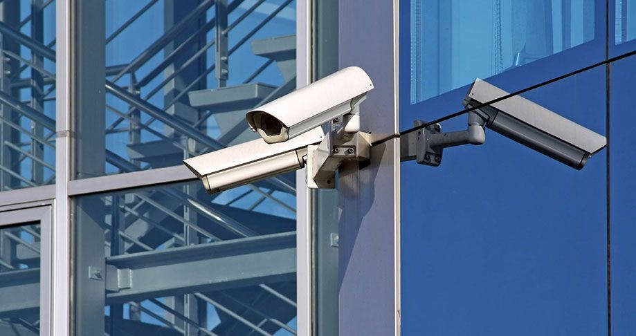 Two security cameras are mounted on the side of a building.