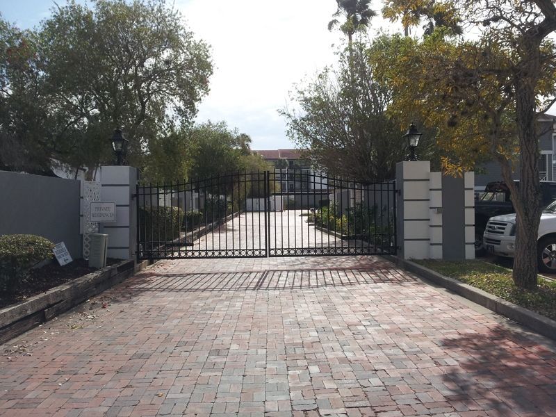 A brick driveway leading to a gated community