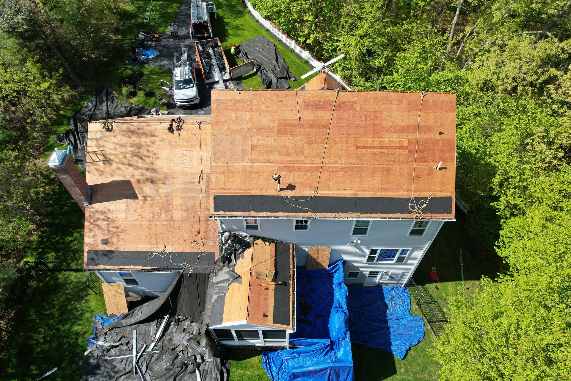 An aerial view of a house with a roof that is being repaired.