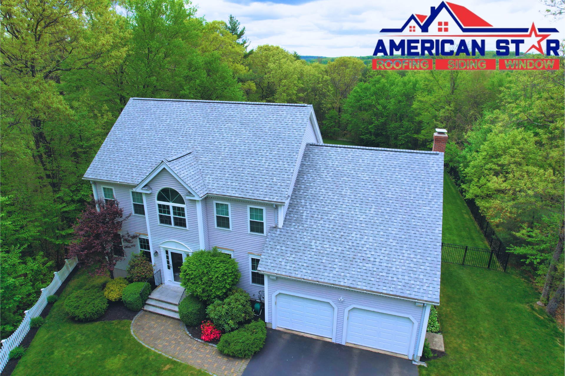 An aerial view of a white house with a gray roof