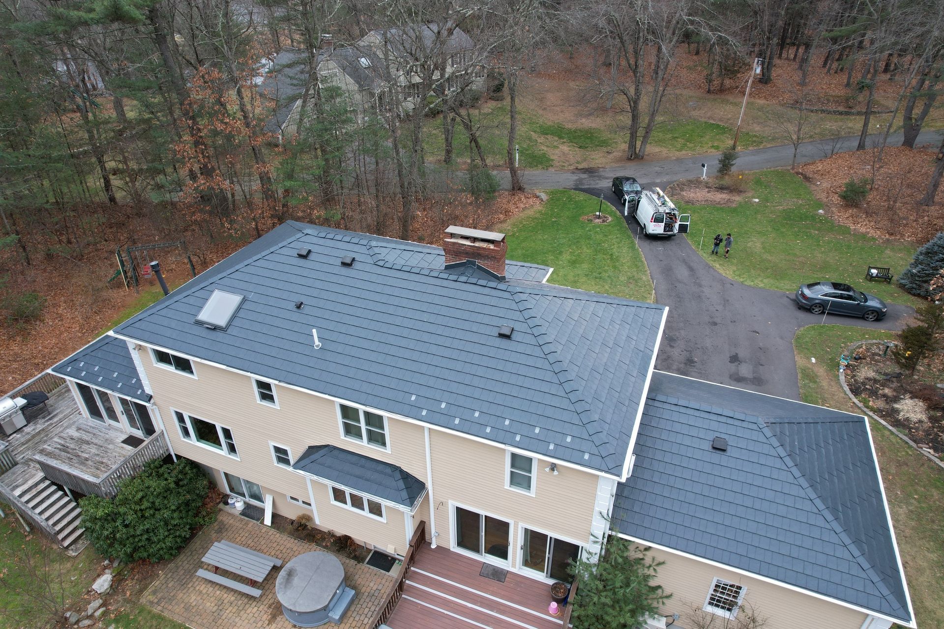 An aerial view of a large house with a blue roof.