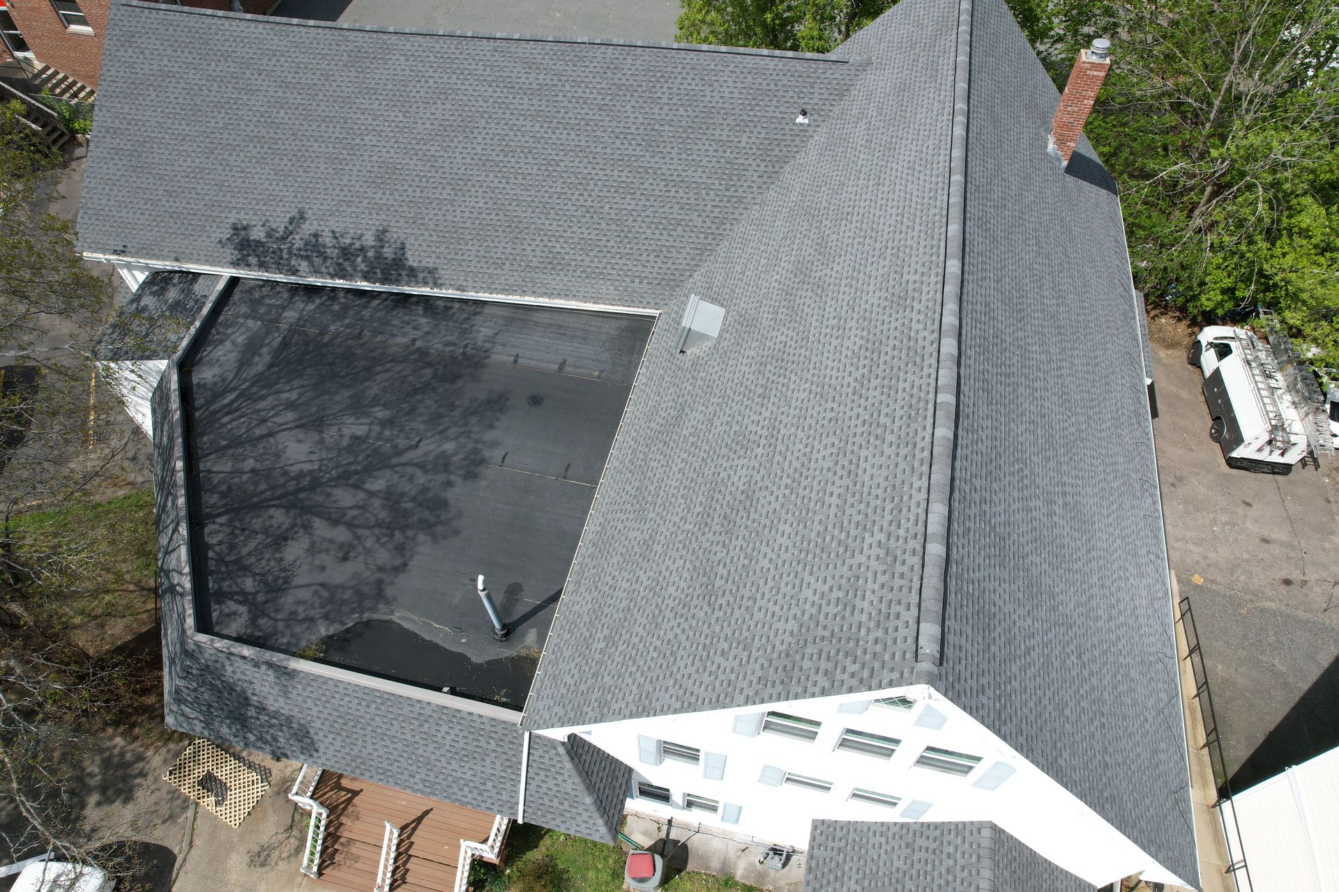 An aerial view of a large house with a black roof.