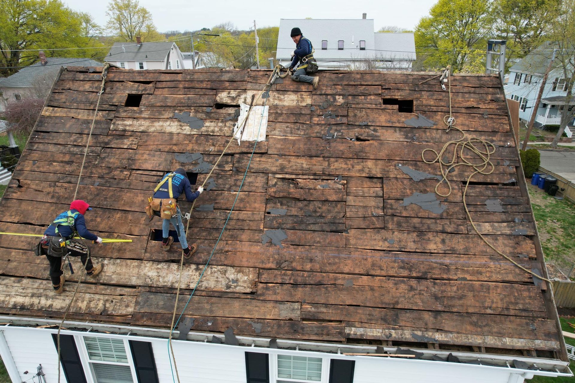 A group of men are working on the roof of a house.