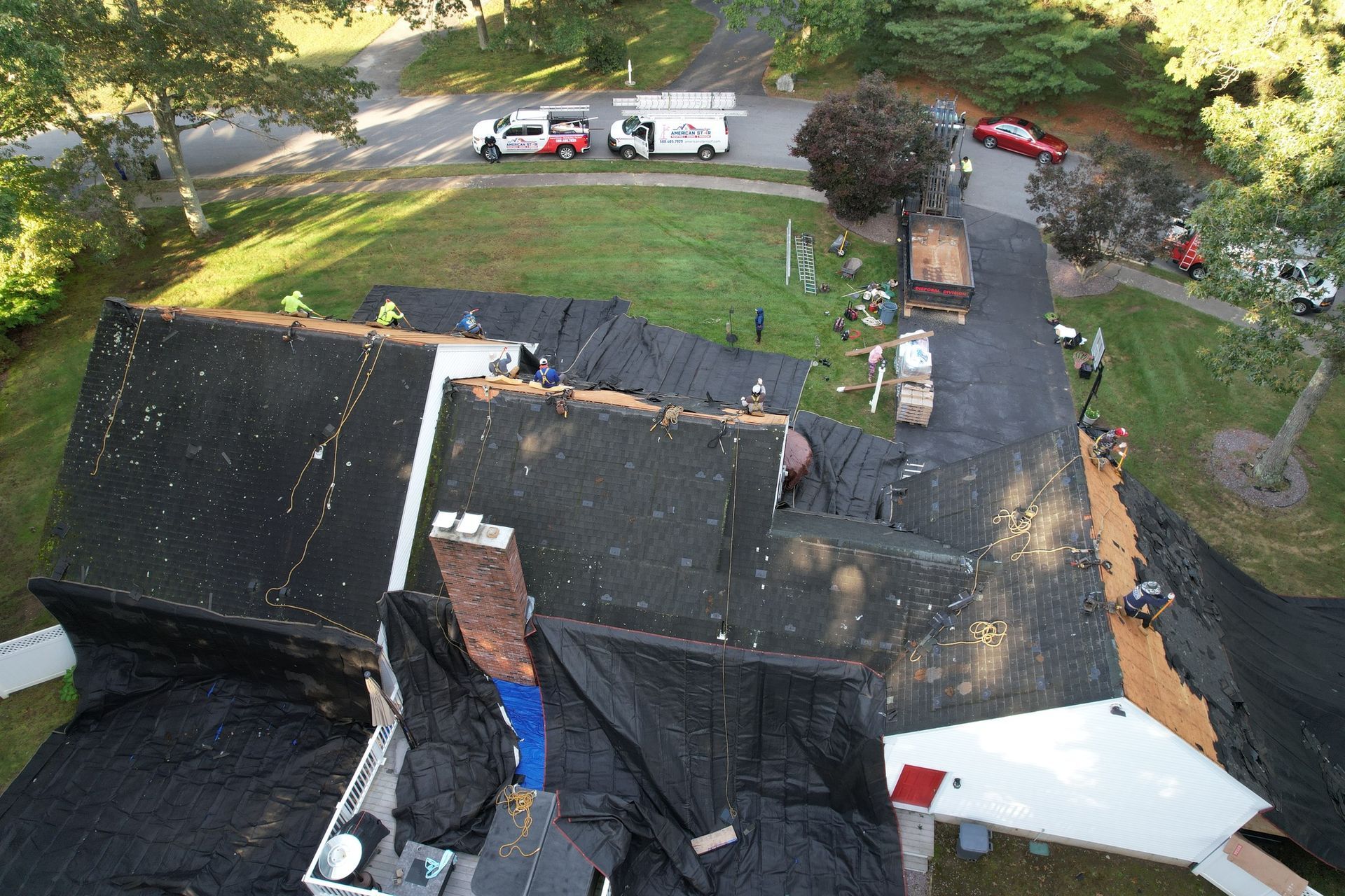 An aerial view of a house with a roof being repaired.