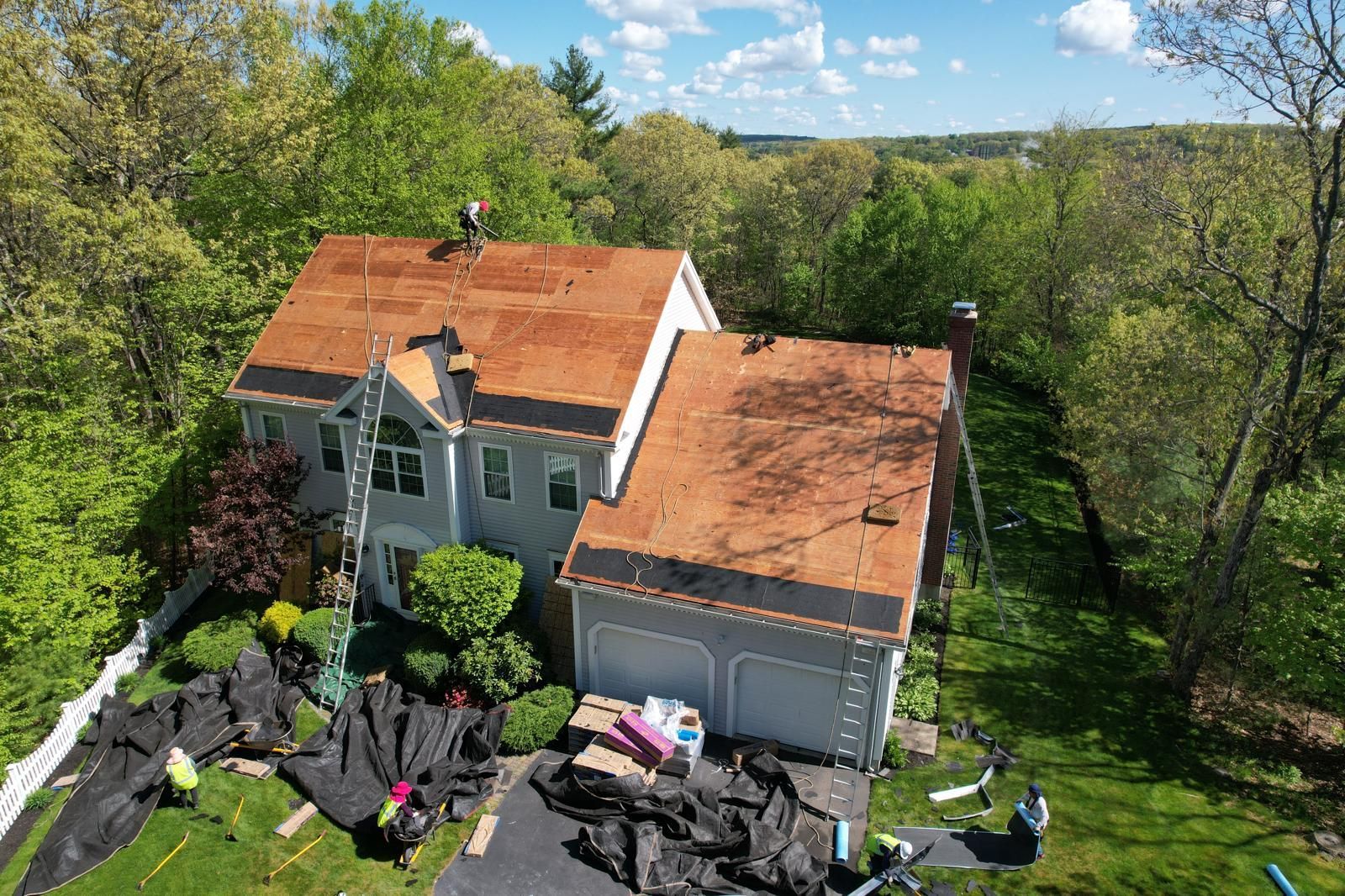 An aerial view of a house with a new roof being installed.