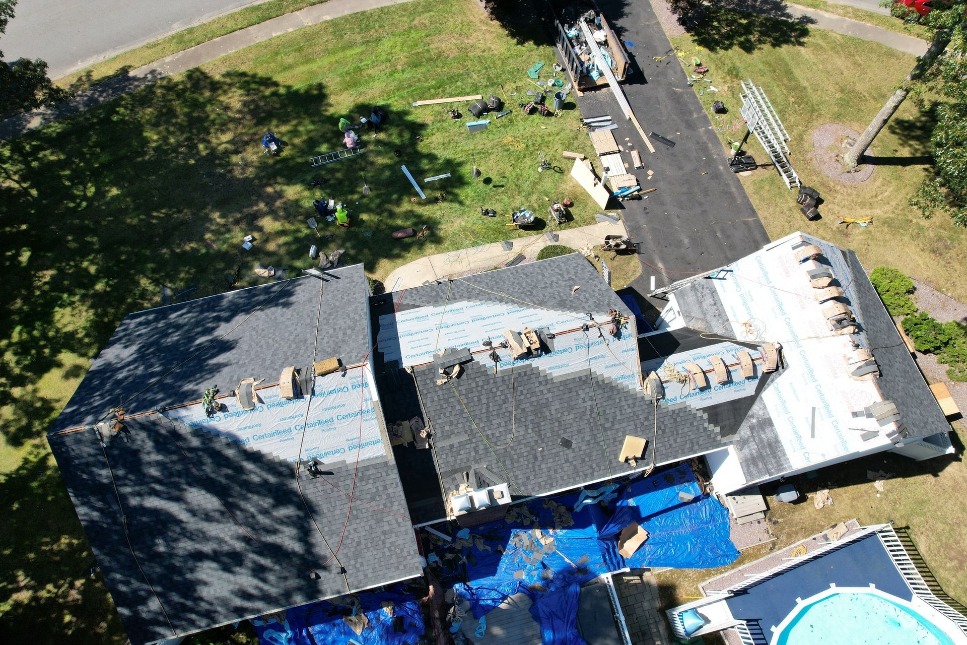 An aerial view of a house under construction with a pool in the backyard.