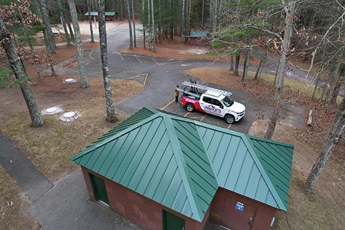 An aerial view of a truck parked on top of a green roof.