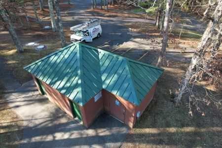 An aerial view of a small building with a green roof.