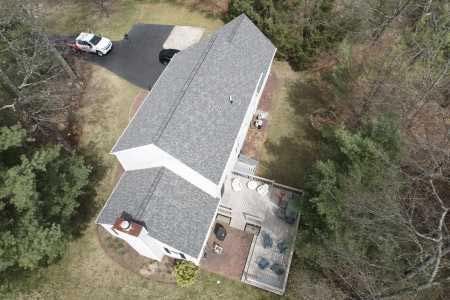 An aerial view of a house with a car parked in the driveway.