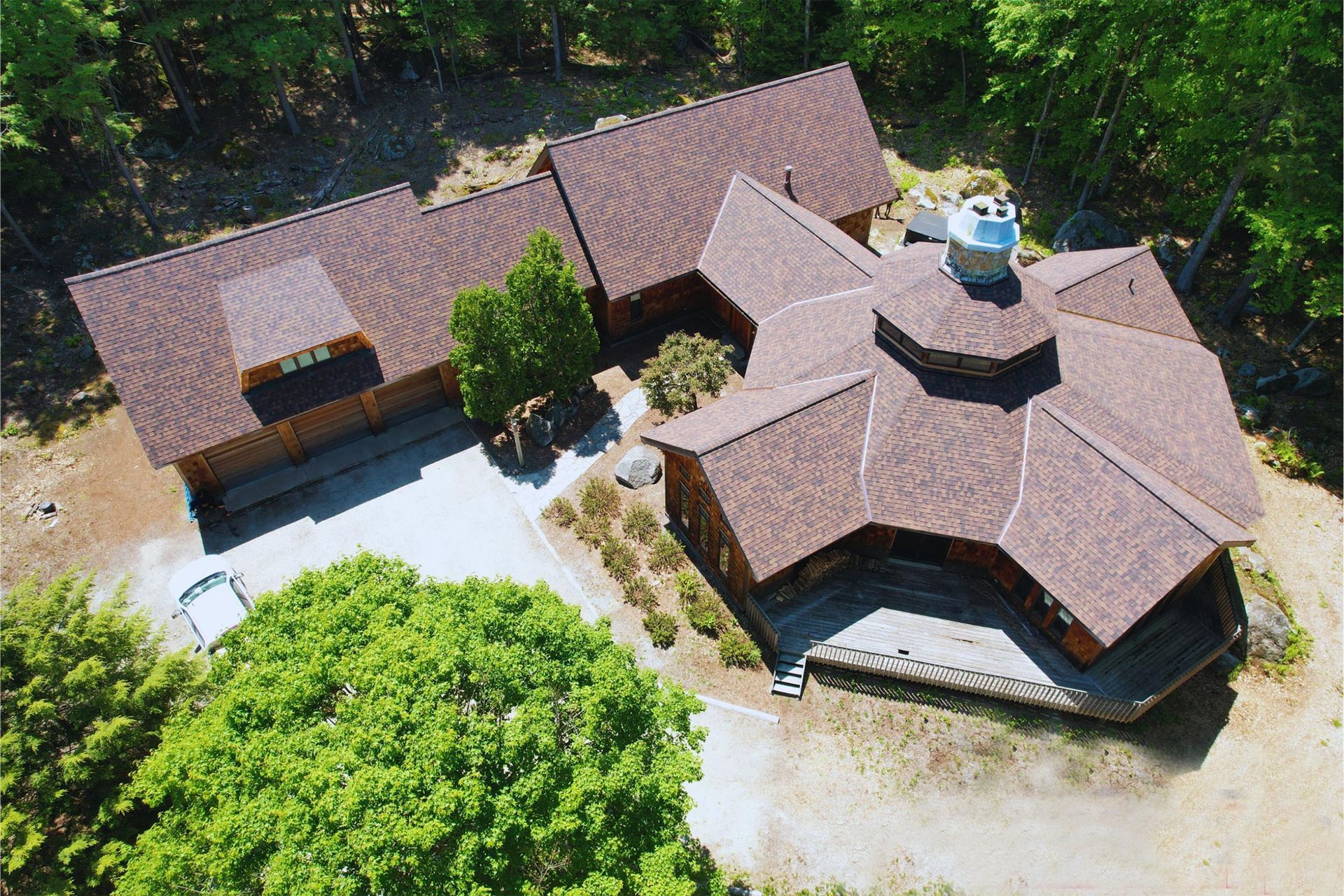 An aerial view of a house in the middle of a forest