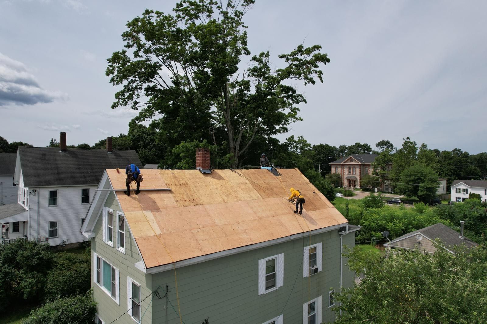Two men are working on the roof of a house