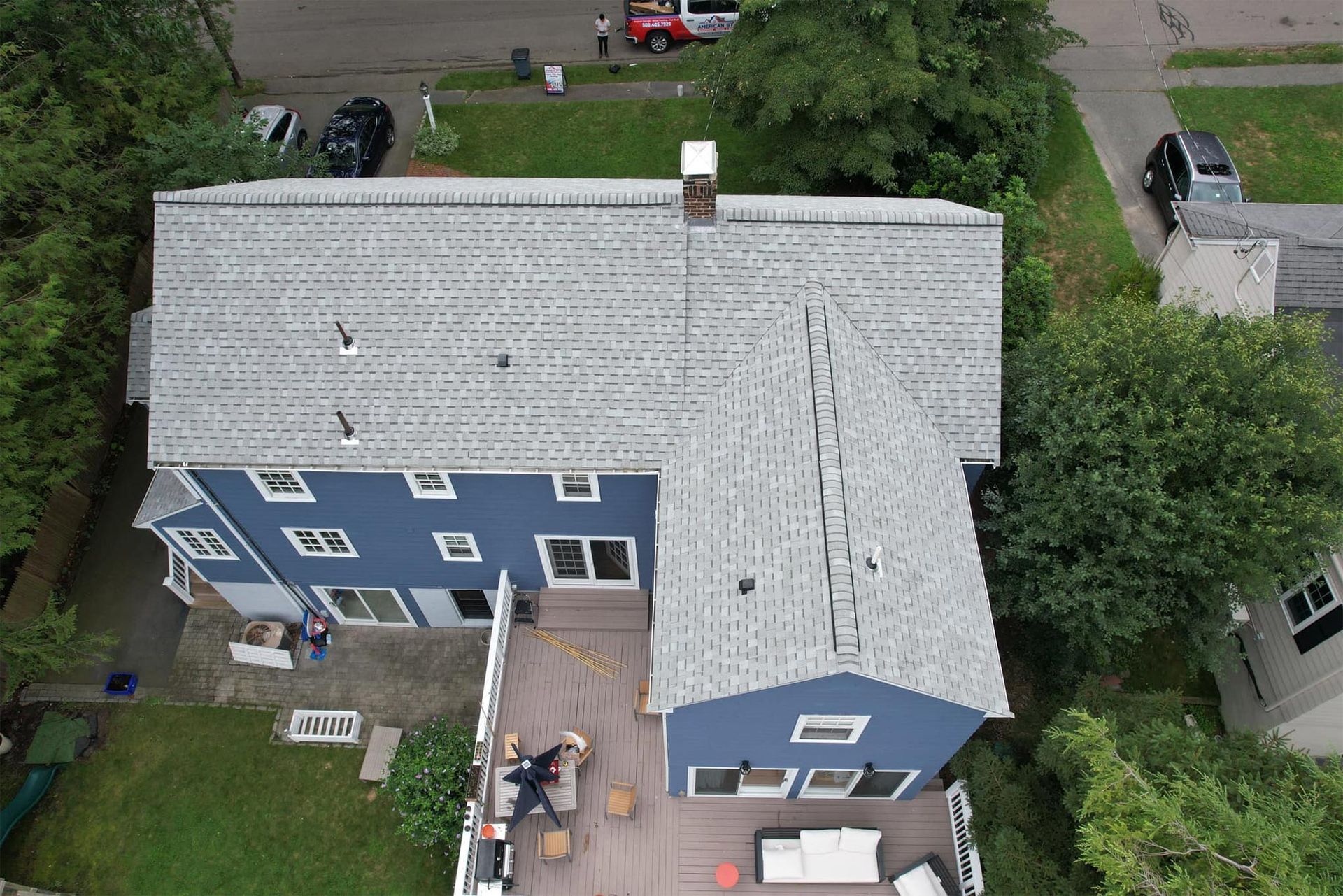 An aerial view of a blue house with a white roof