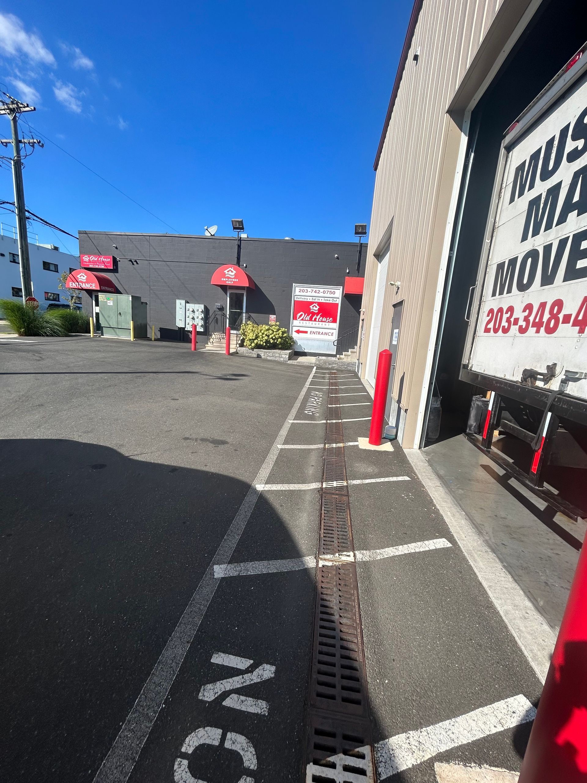A white moving truck is parked in front of a building