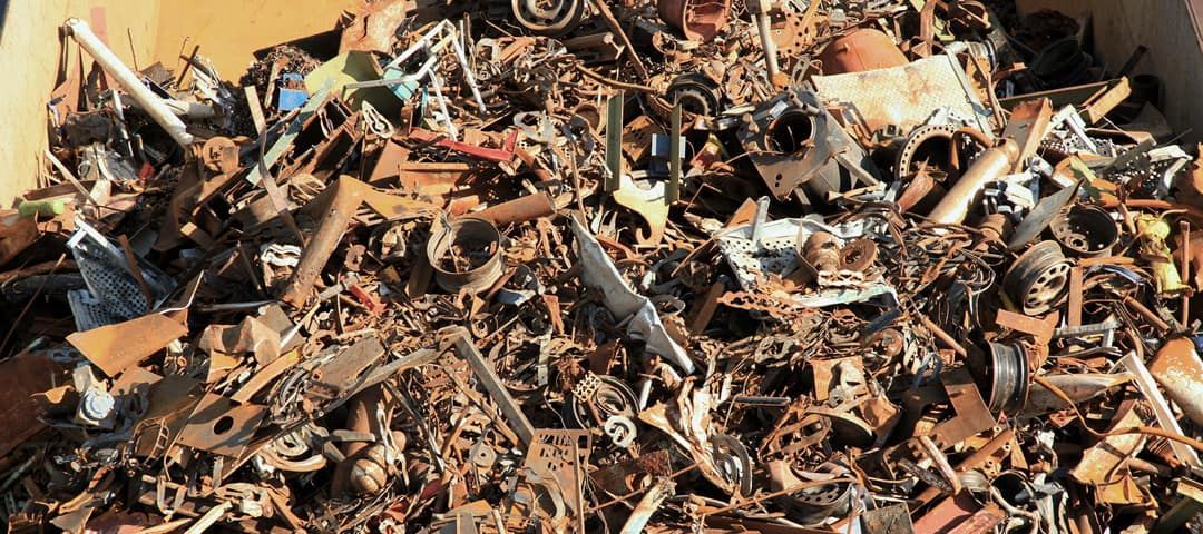Pile of scrap metal, with pieces of various sizes and rusty colors.