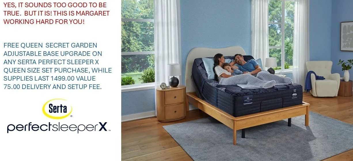 A family lies in bed, reading. The bedroom has a wooden bed frame, a rug, and a light blue wall.