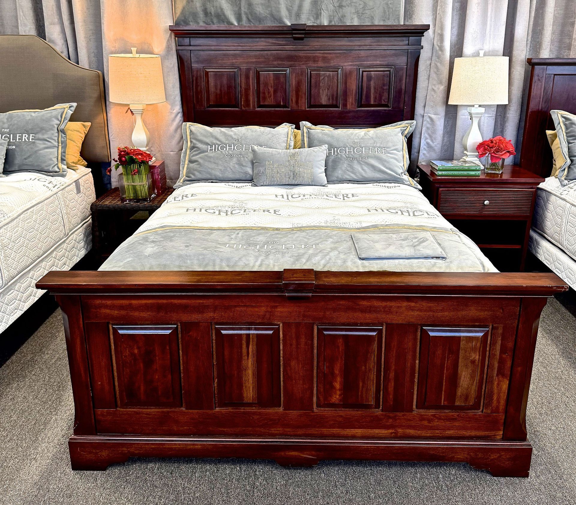 Dark wood bed frame with matching headboard and footboard, flanked by nightstands and lamps.
