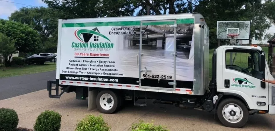 A white truck is parked in a driveway next to a basketball hoop.