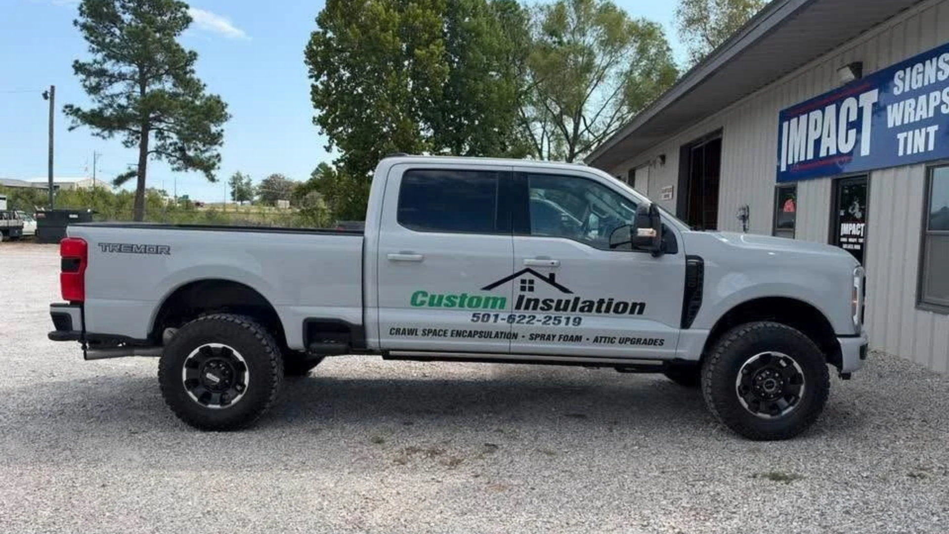 White Custom Insulation pickup truck parked outside a Impact window tint shop.