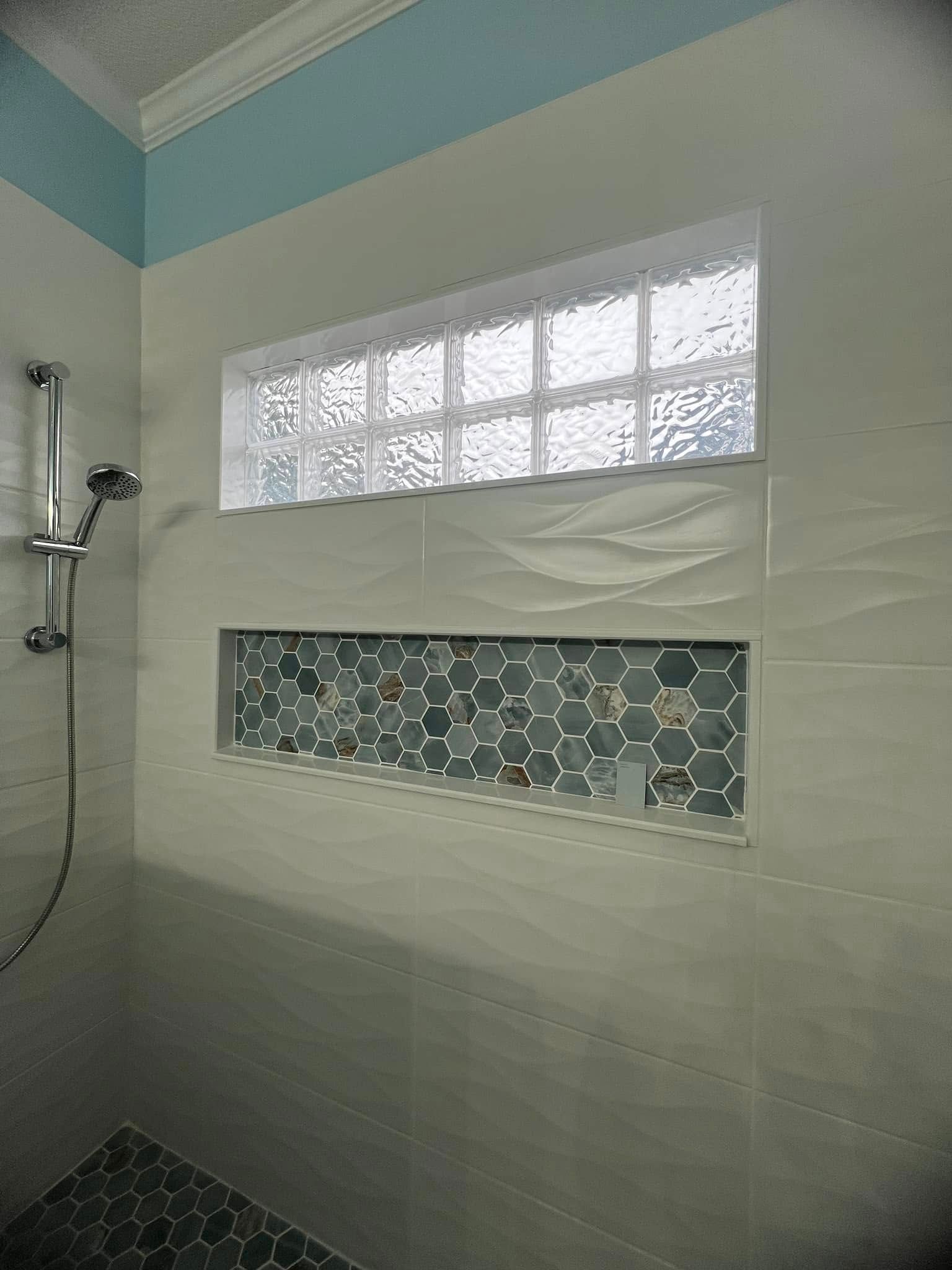 A shower with a window and a shelf in it.