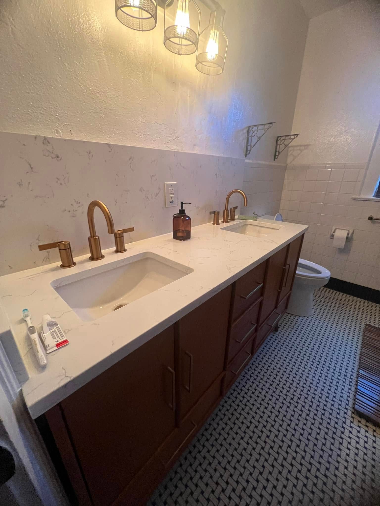 A bathroom with two sinks and a toilet.