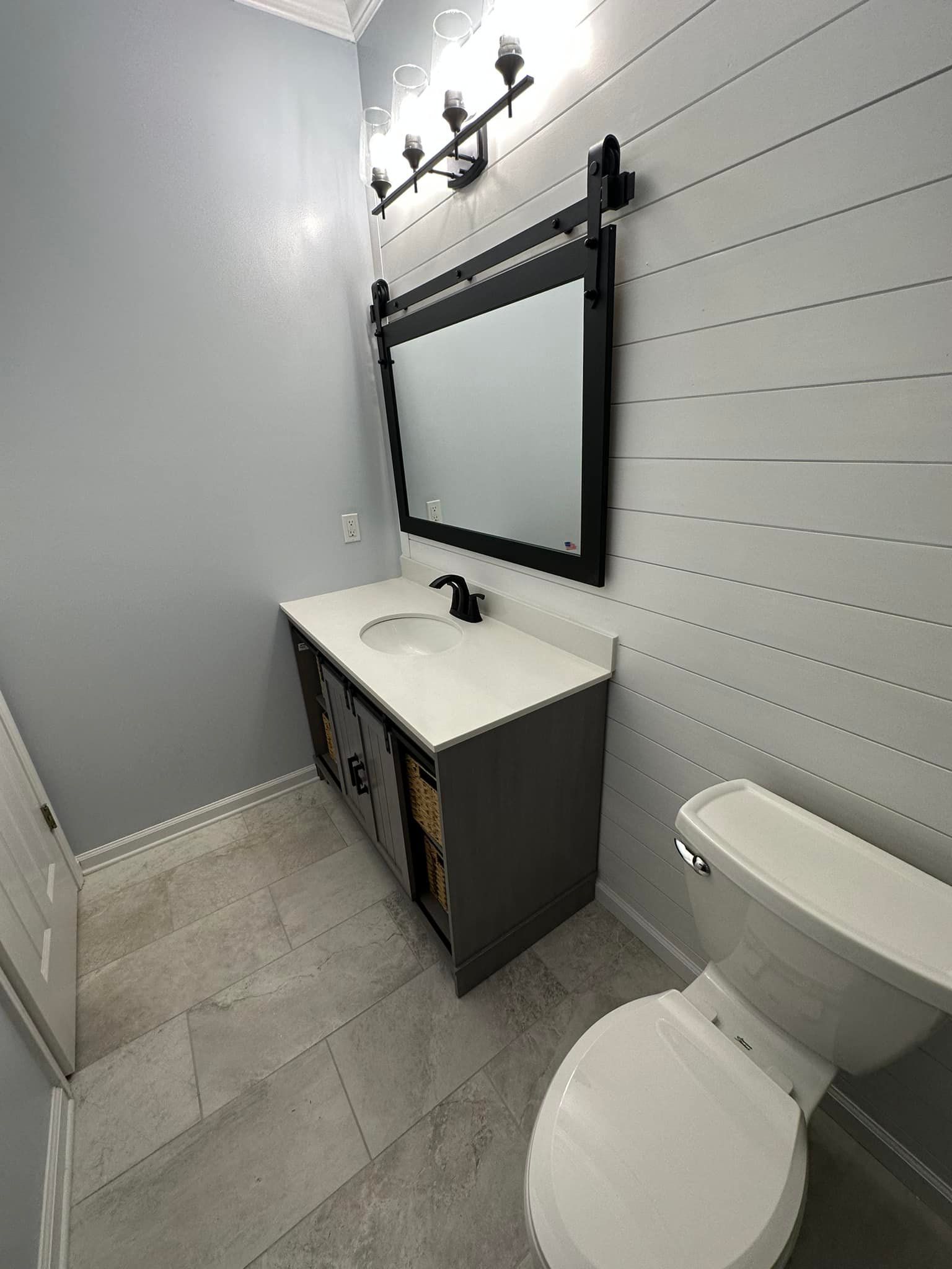 A bathroom with a sink, toilet and mirror.
