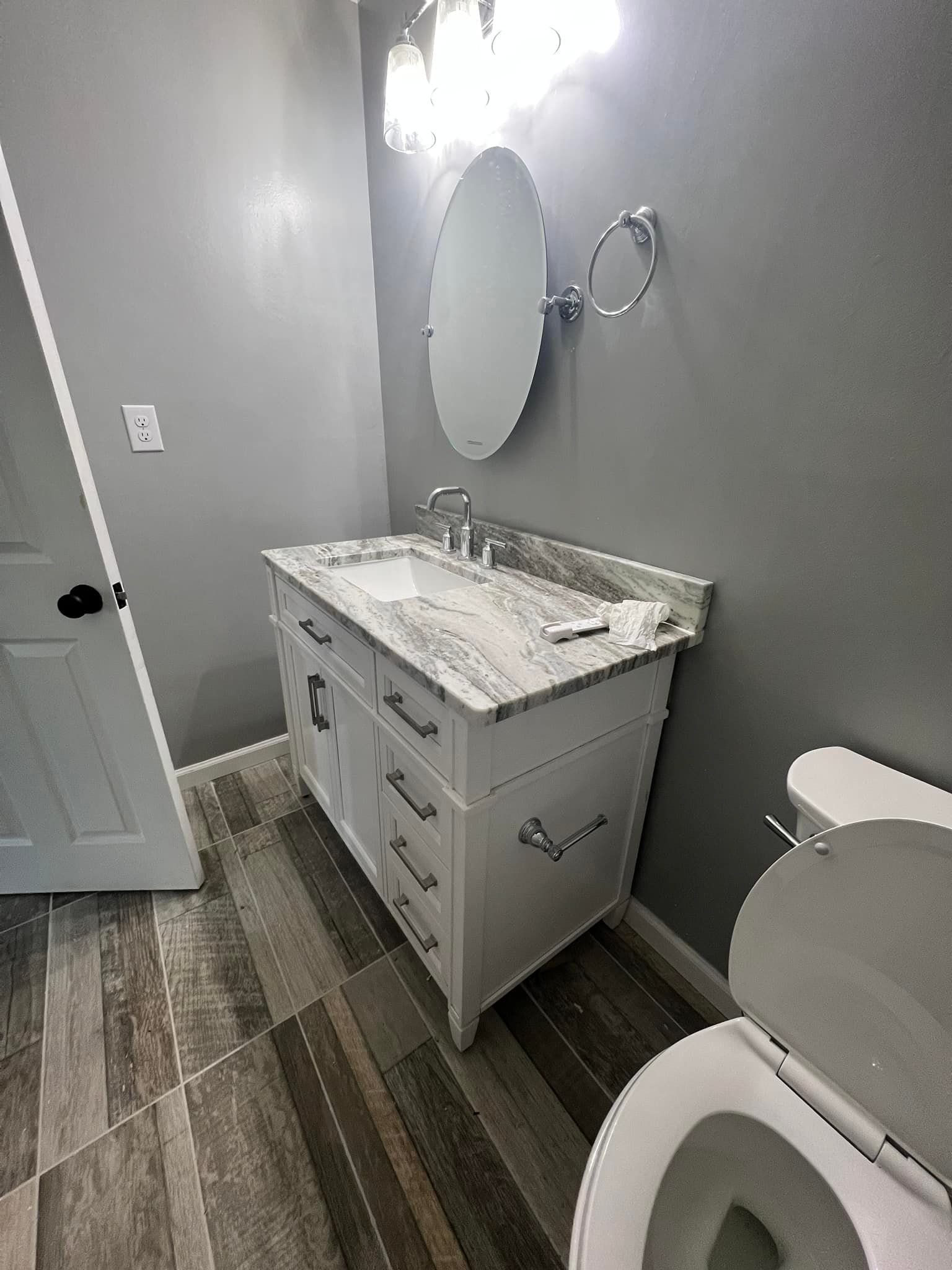 A bathroom with a sink, toilet and mirror.
