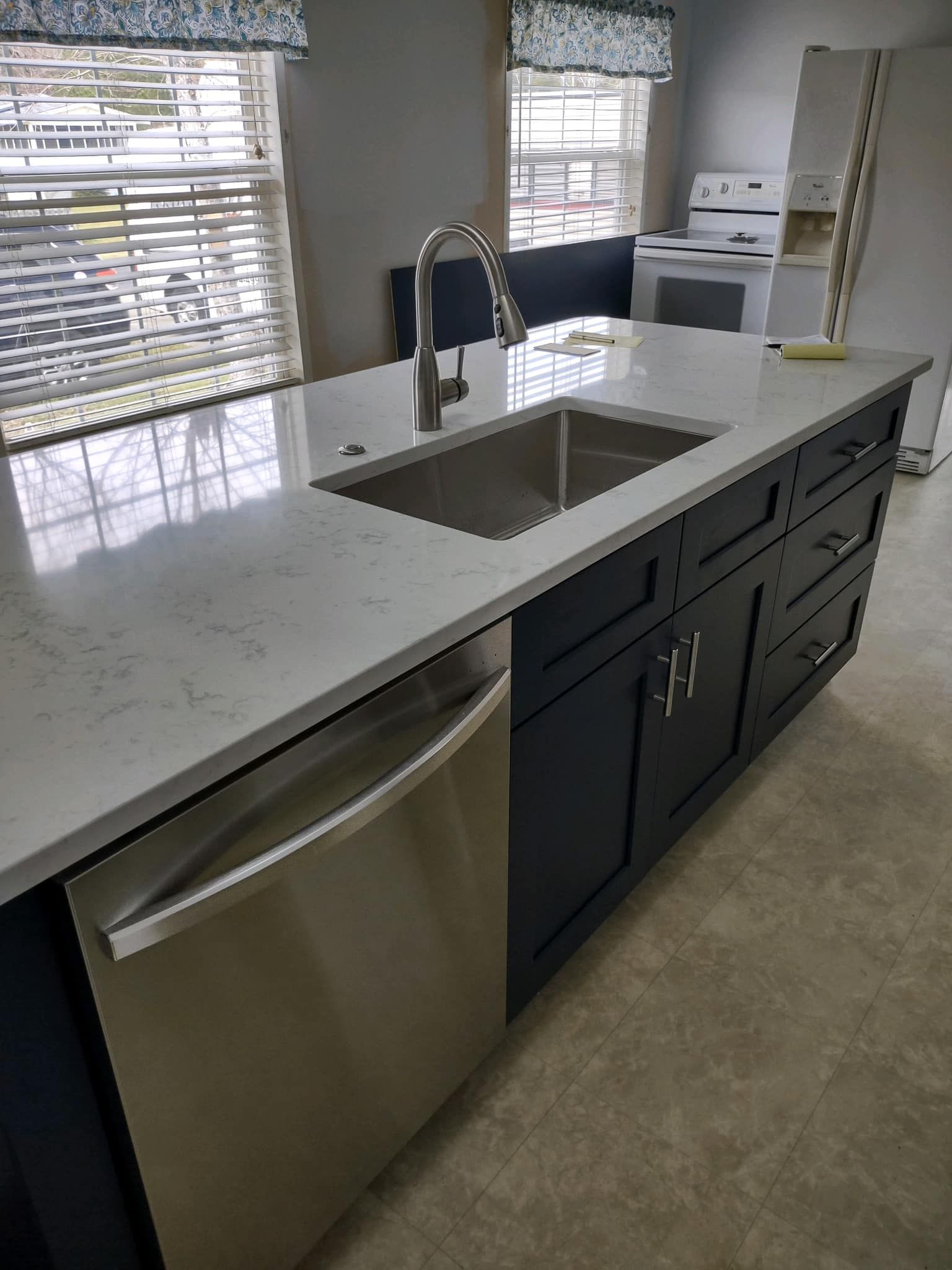 A kitchen with a stainless steel sink and a stainless steel dishwasher.