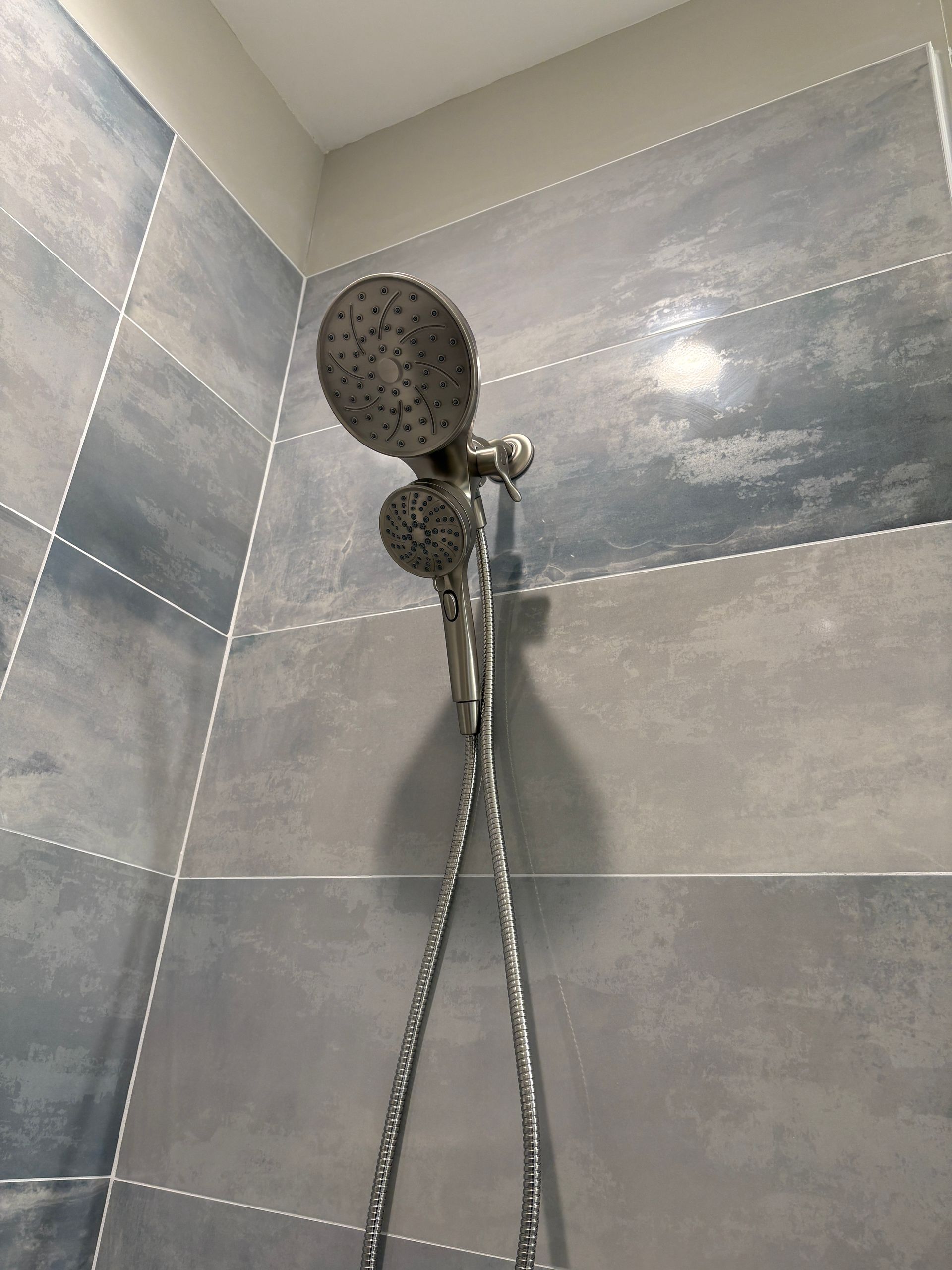 A close up of a shower head in a bathroom.