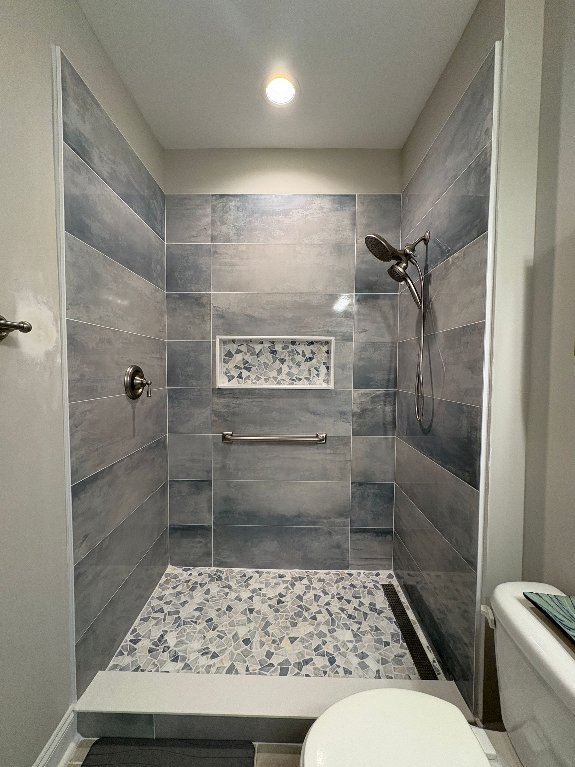 A bathroom with a walk in shower and a toilet.