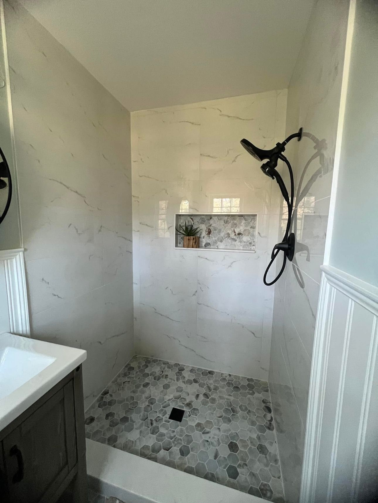 A bathroom with a walk in shower and a sink.