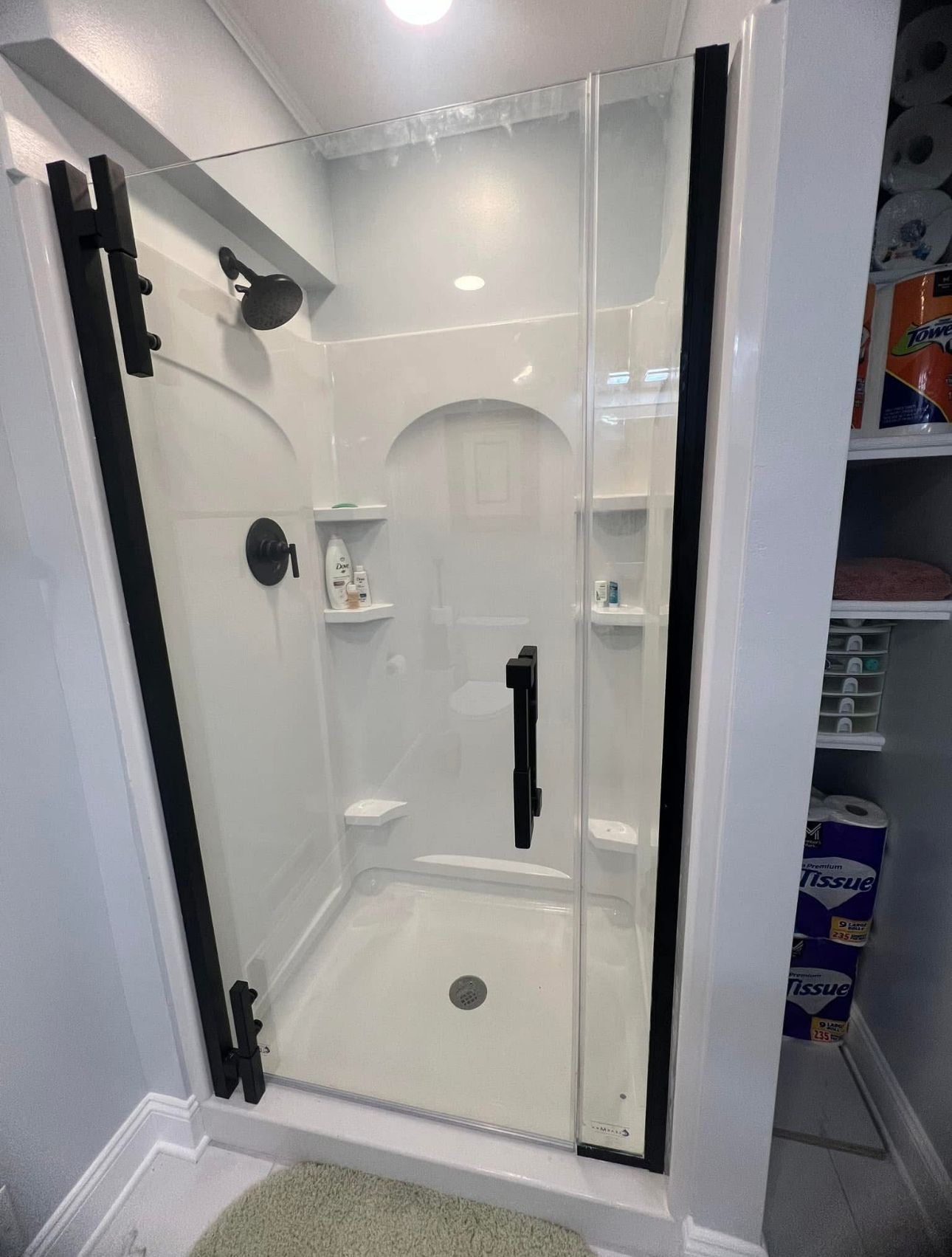 A bathroom with a shower stall and a sliding glass door.
