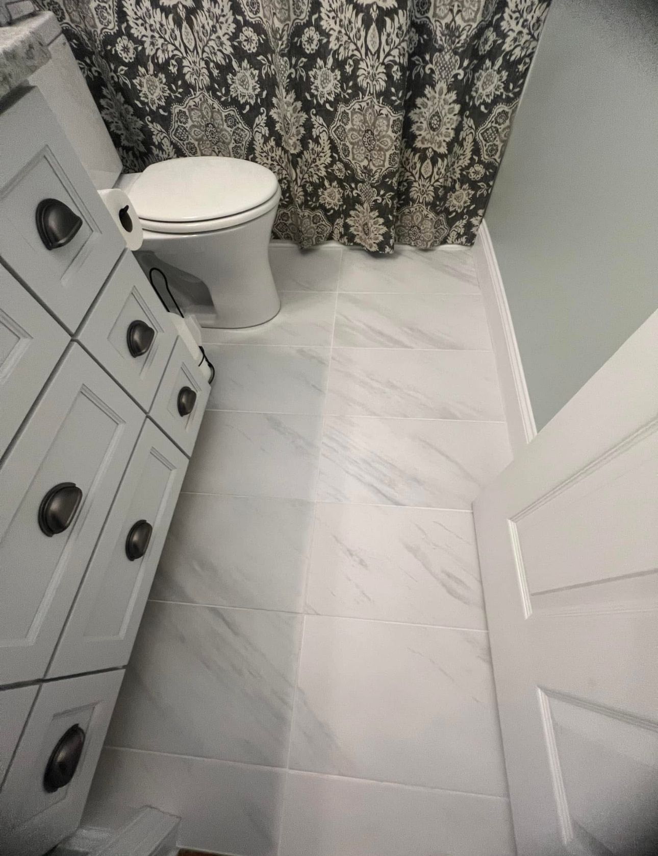 A bathroom with a toilet, sink, and shower curtain.