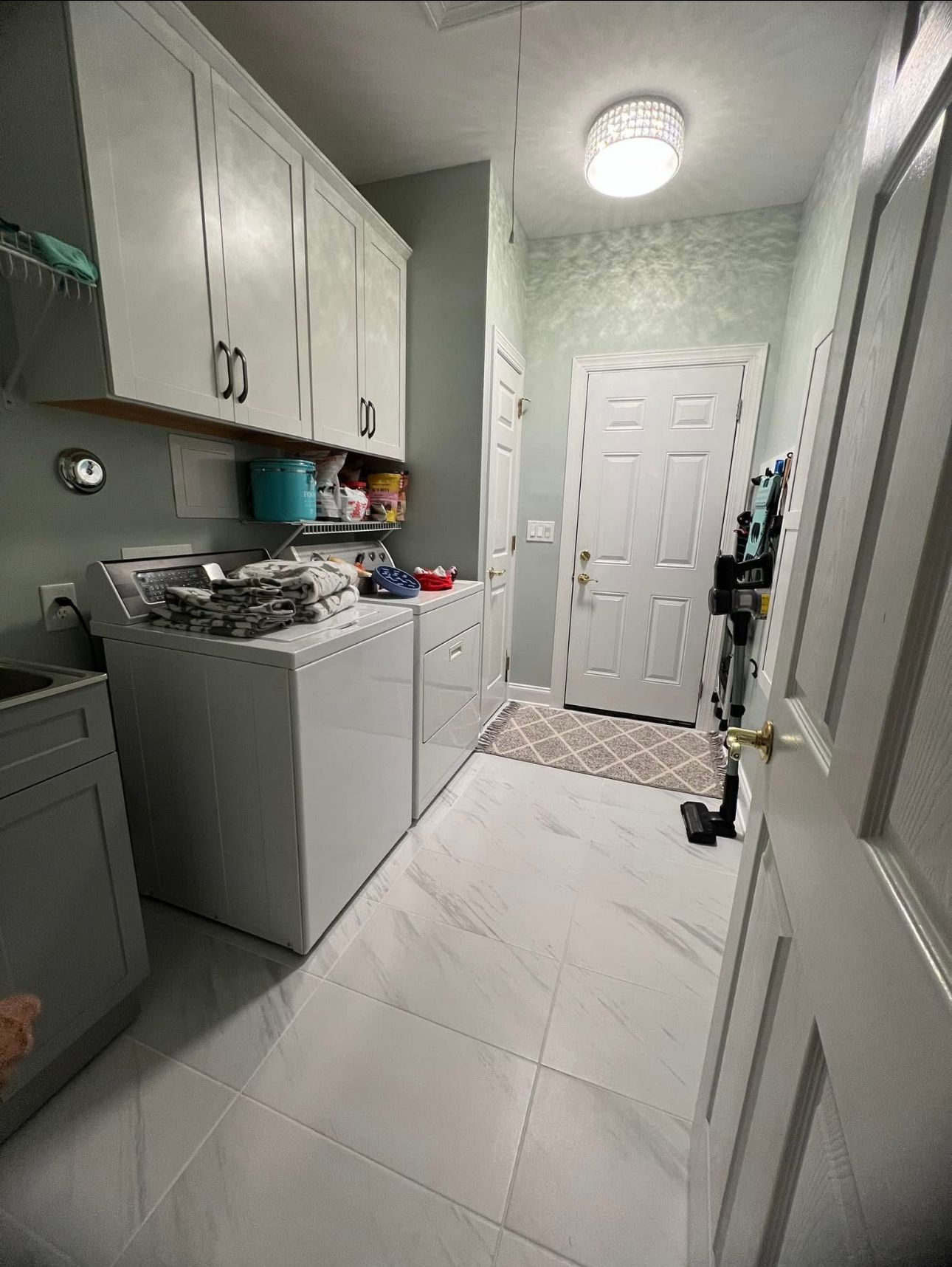 A laundry room with a washer and dryer and a sink.