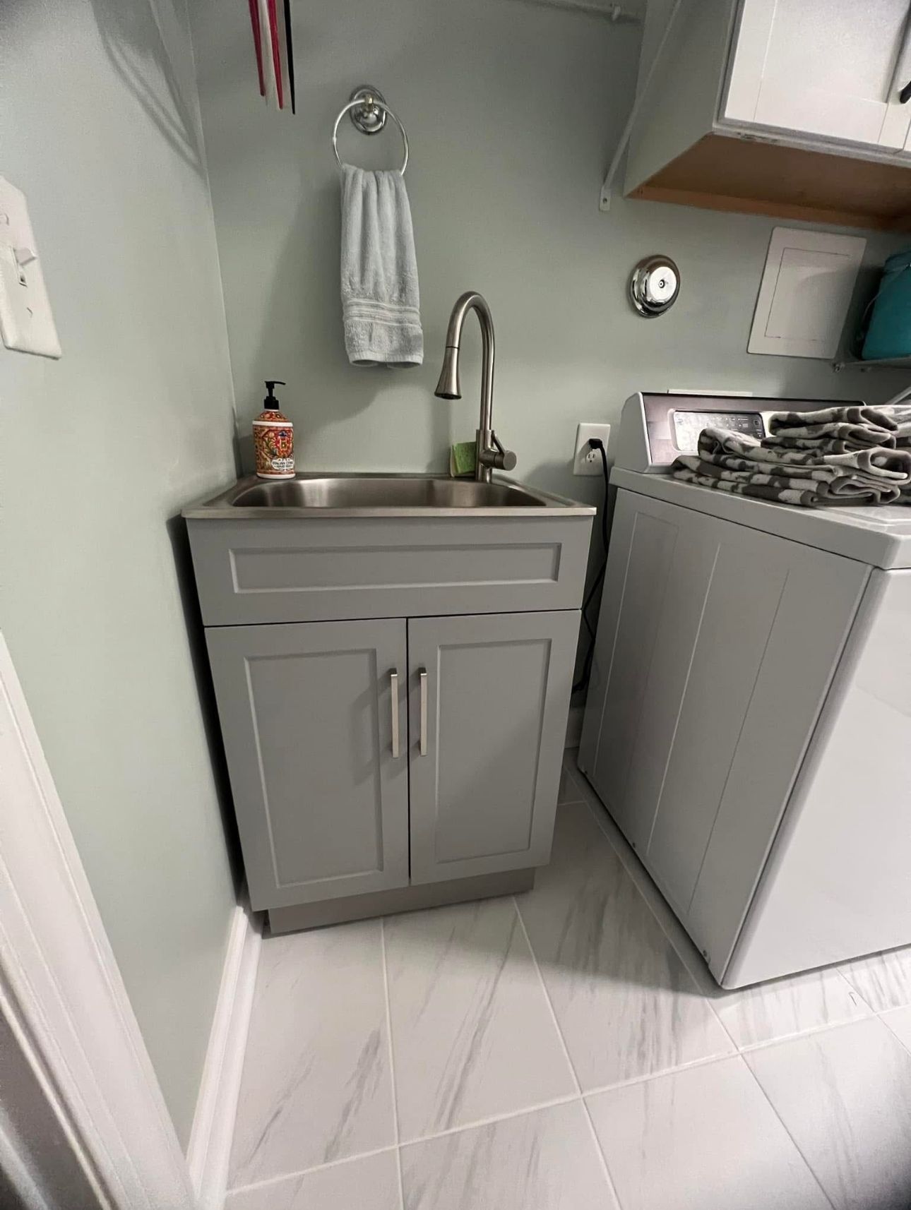 A laundry room with a sink, washer, and dryer.