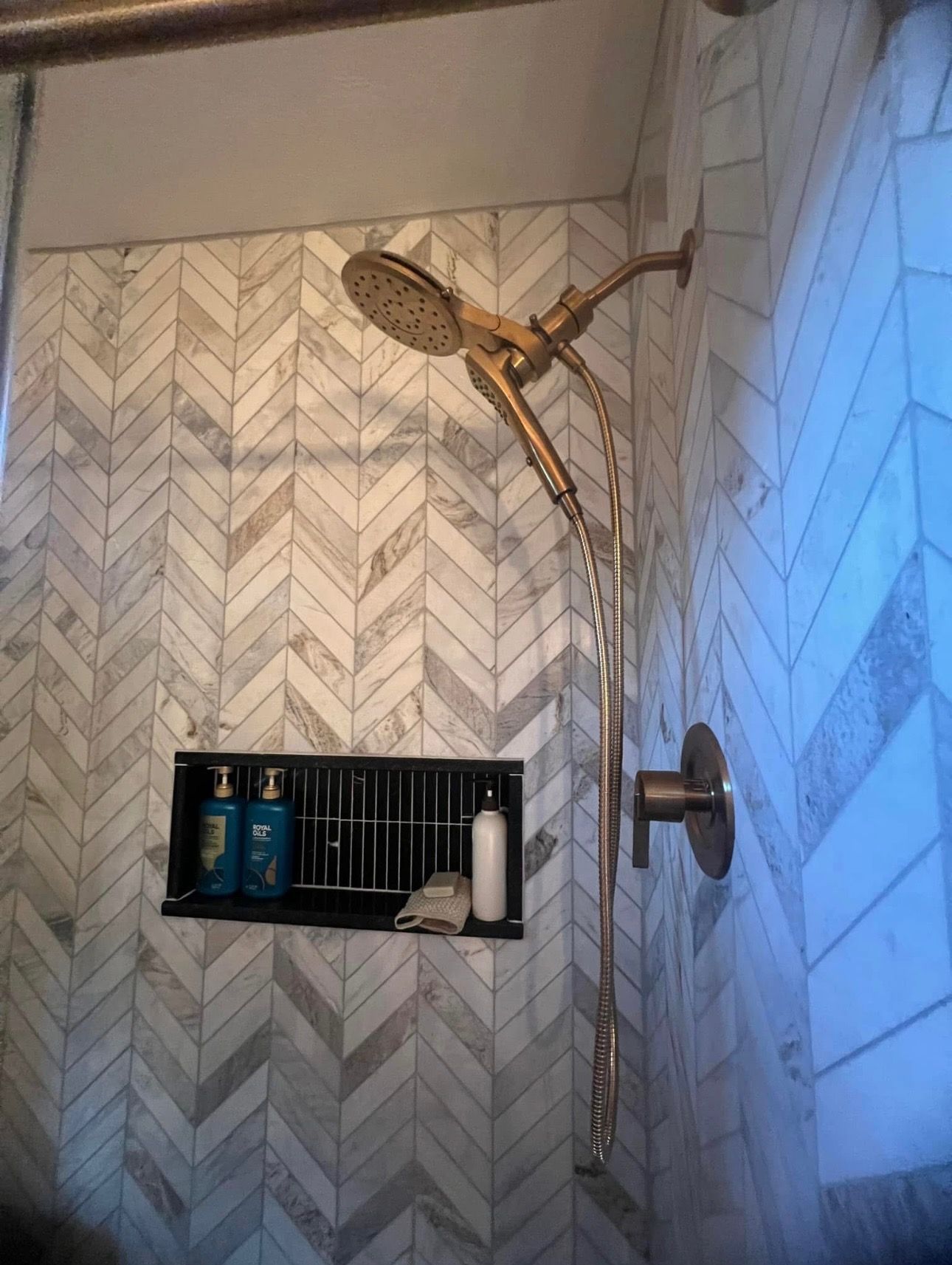 A shower head is hanging from the ceiling in a bathroom.